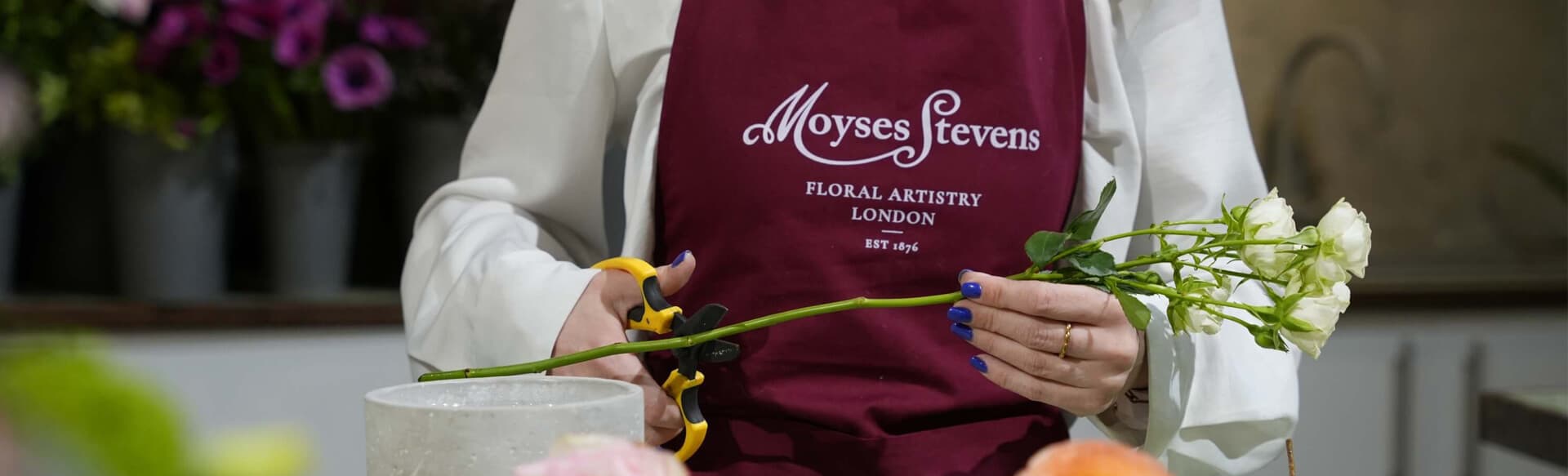 A Moyses Stevens florist trimming roses at the Flower School