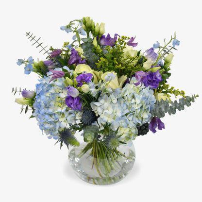 Blue sky luxury flower bouquet by Moyses Stevens UAE featuring Blue Hydrangeas, White Roses, Purple Lisianthus, Purple Clematis, Blue Delphinium, Yellow Solidago, Eucalyptus