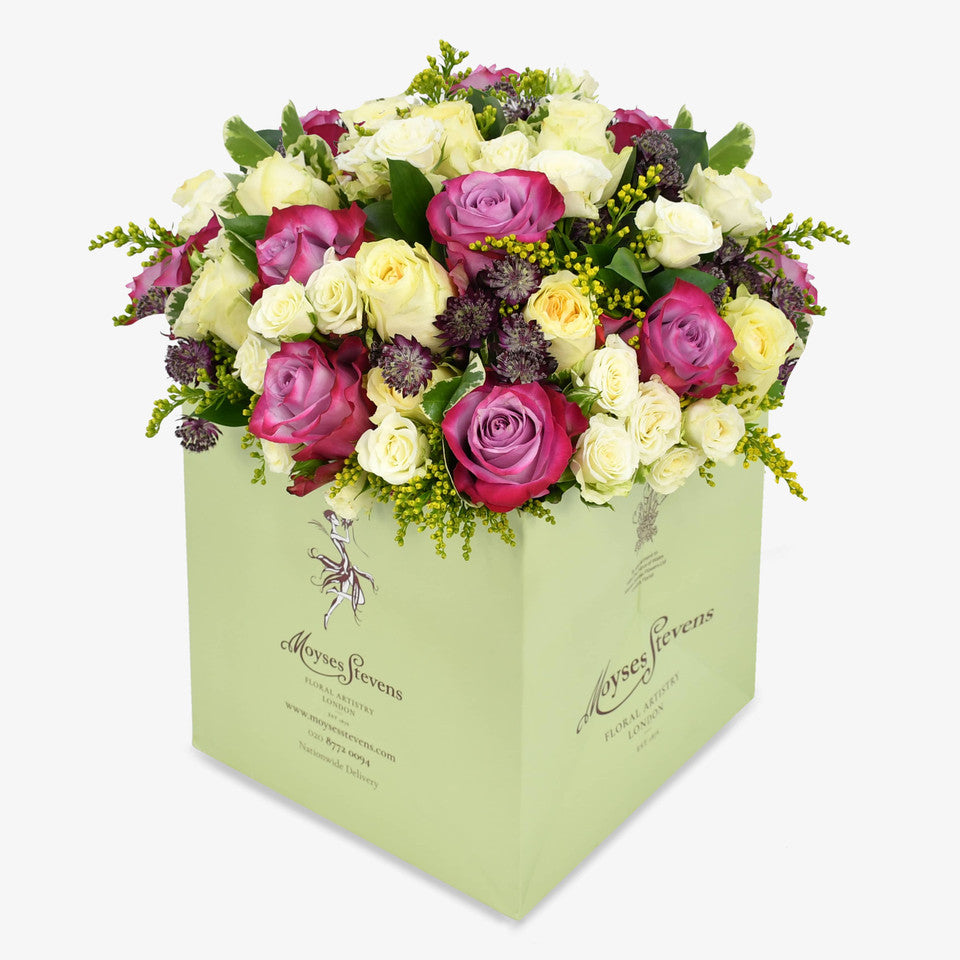 Lemon Meringue luxury flower bouquet by Moyses Stevens UAE featuring yellow and deep purple roses, white spray roses, solidago and astrantia and  seasonal greenery.