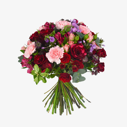 Plush Passion luxury flower bouquet by Moyses Stevens UAE featuring red roses, pink and red spray roses, pink alstroemeria, astrantia and purple phlox.