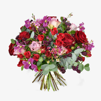 Rennaisance Rose luxury flower bouquet by Moyses Stevens UAE featuring a variety of red and pink roses, spray roses, clematis, wax flower, astrantia, and eucalyptus.